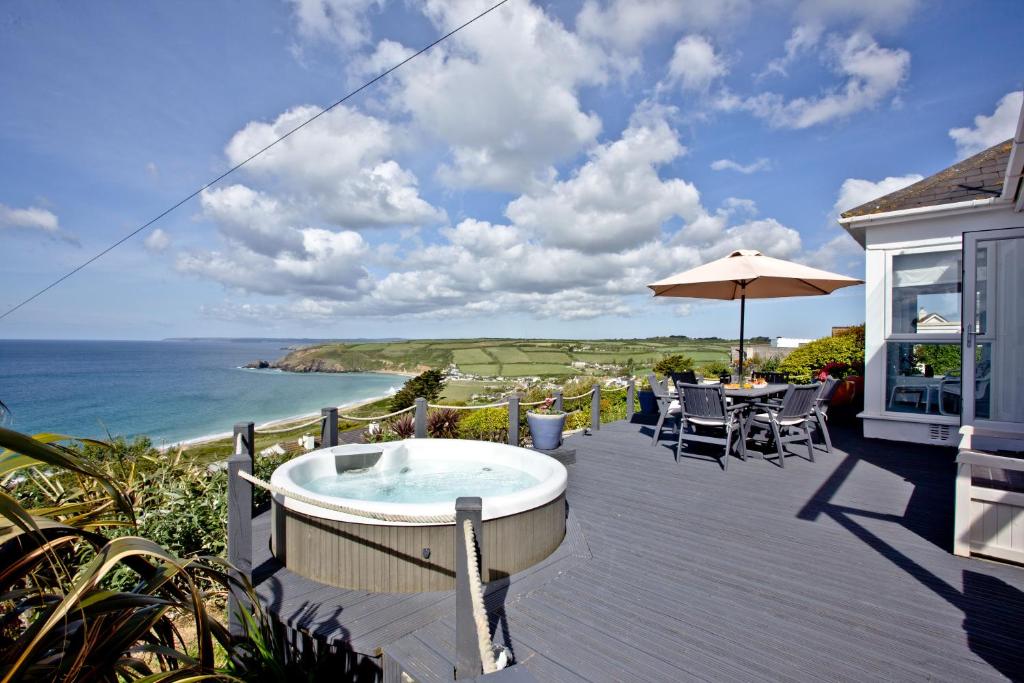 a deck with a hot tub and a table and chairs at Spindrift in Praa Sands