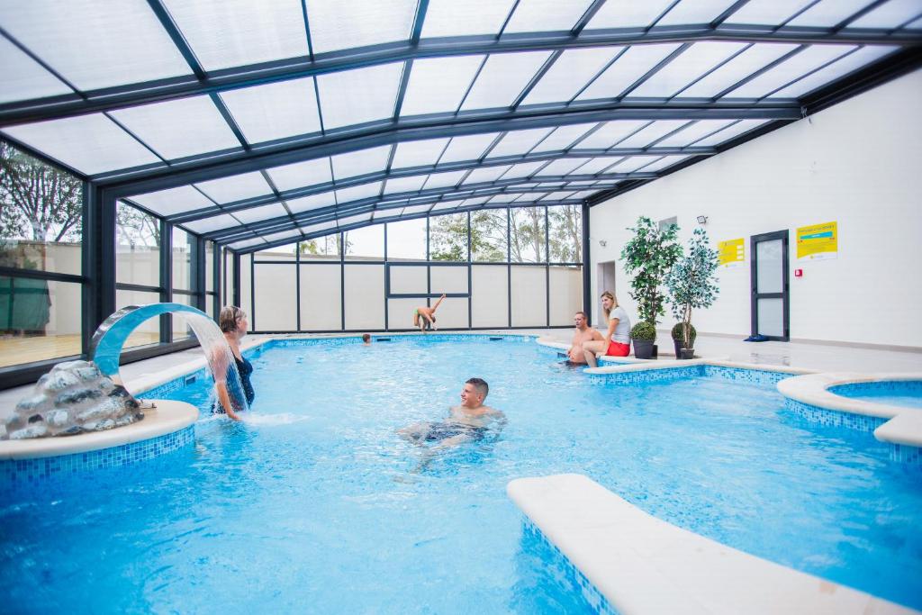 a group of people in a swimming pool at Mobil Home XXL 4 chambres - Camping Le Brabois in Villers-lès-Nancy