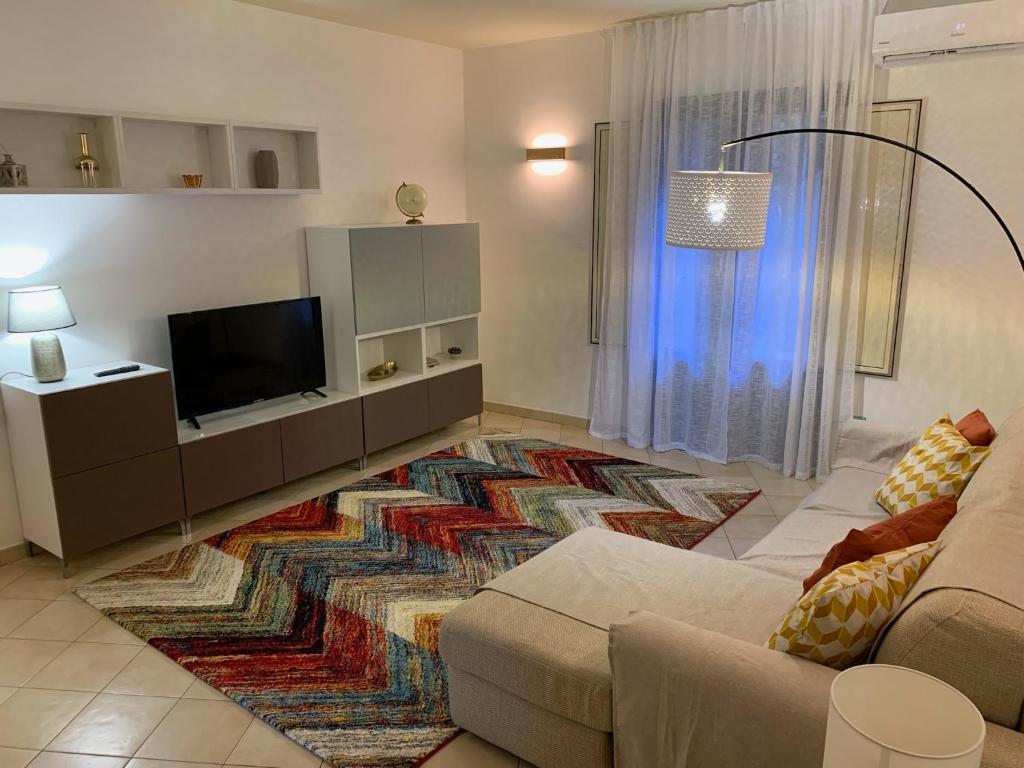 un soggiorno con divano e TV a schermo piatto di Terre dAci Apartments - casa Vastea ad Acireale