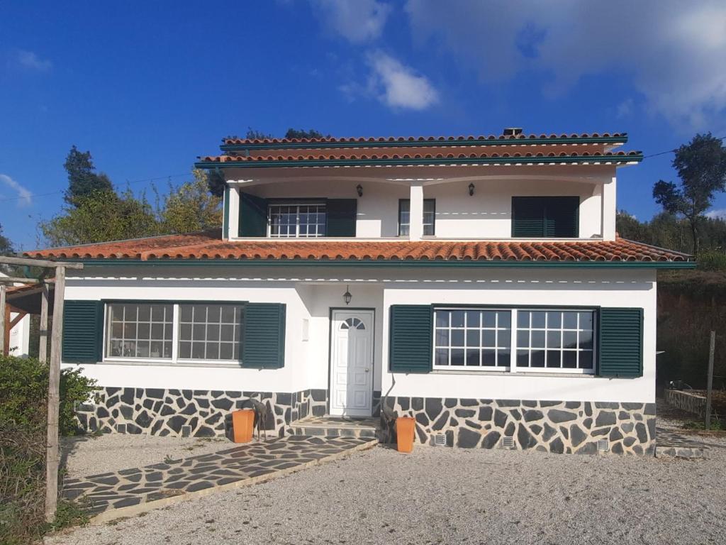 een wit huis met groene luiken erop bij Casa-Estaro in Anceriz