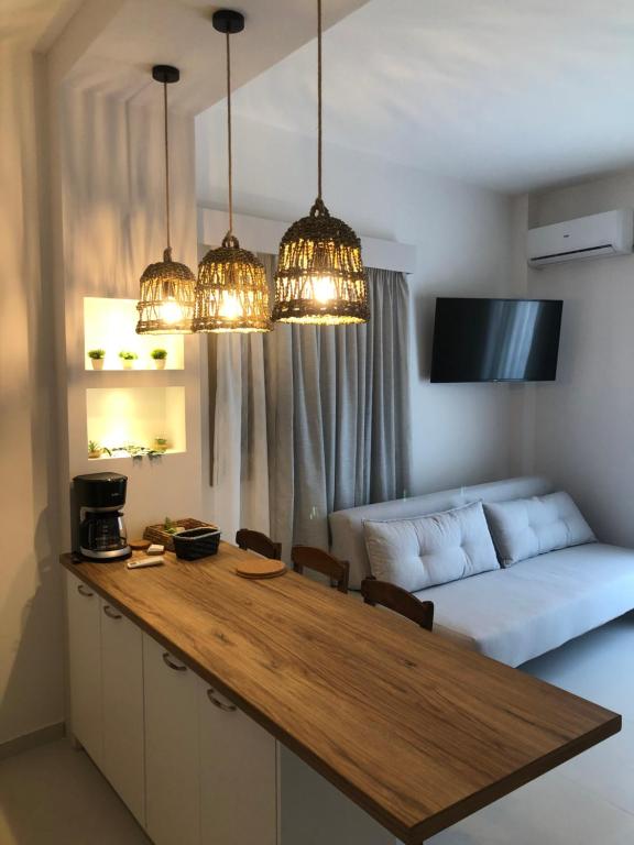 uma sala de estar com uma mesa e um sofá em Fays luxury apartments by the sea em Finikounta