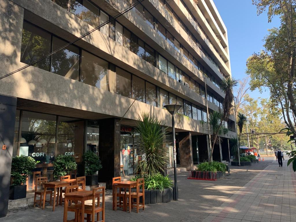 a building with tables and chairs in front of it at Providencia Pedro de Valdivia 0200 in Santiago