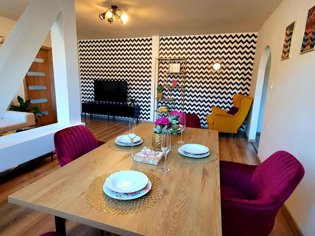 een eetkamer met een houten tafel en paarse stoelen bij Apartmán Frida in Nová Baňa