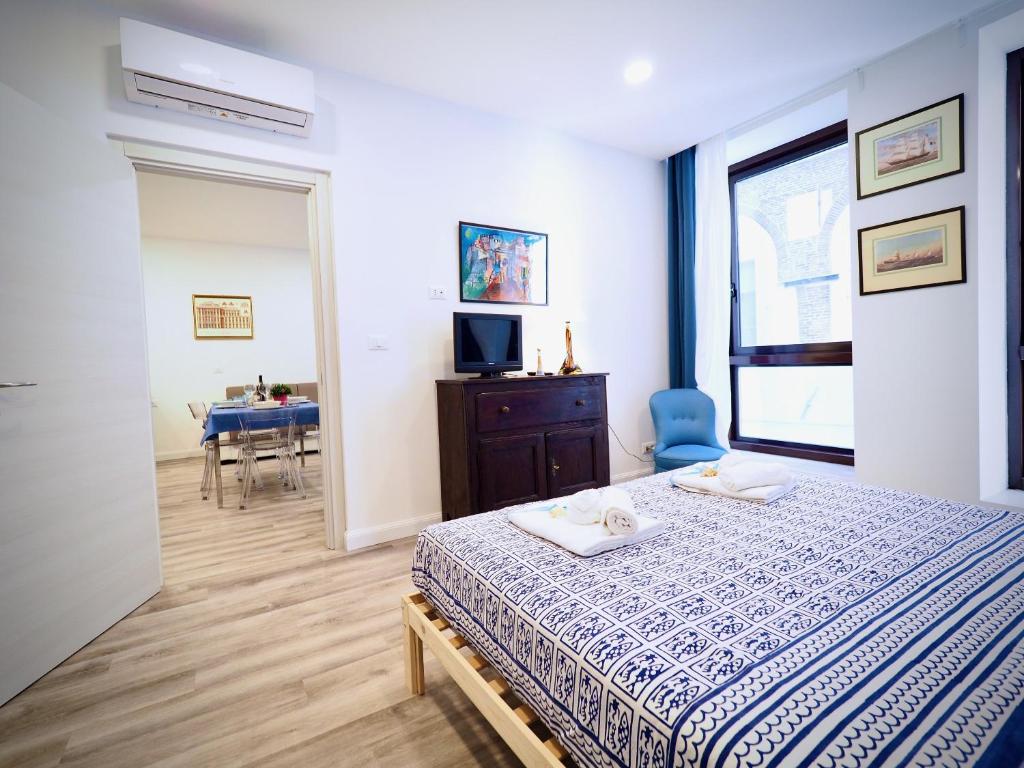 1 dormitorio con 1 cama con silla azul y mesa en DIMORA SOTTORIPA 24 DI FRONTE ALL’ACQUARIO - GENOVABNB IT, en Génova