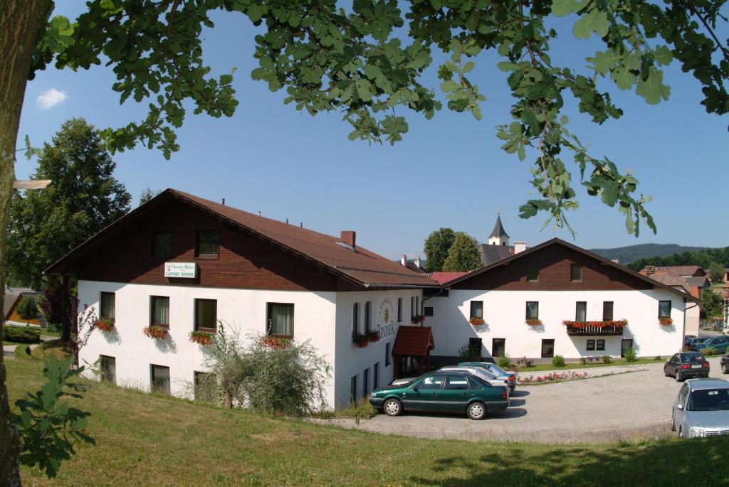 a building with a green car parked in a parking lot at Frühstückspension Binder in Harbach