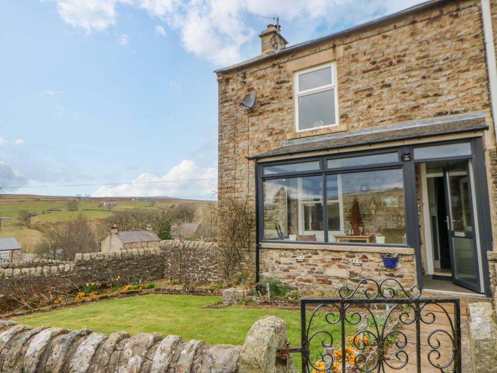 a stone house with a large glass window at 1 Braeside in Burtree Ford