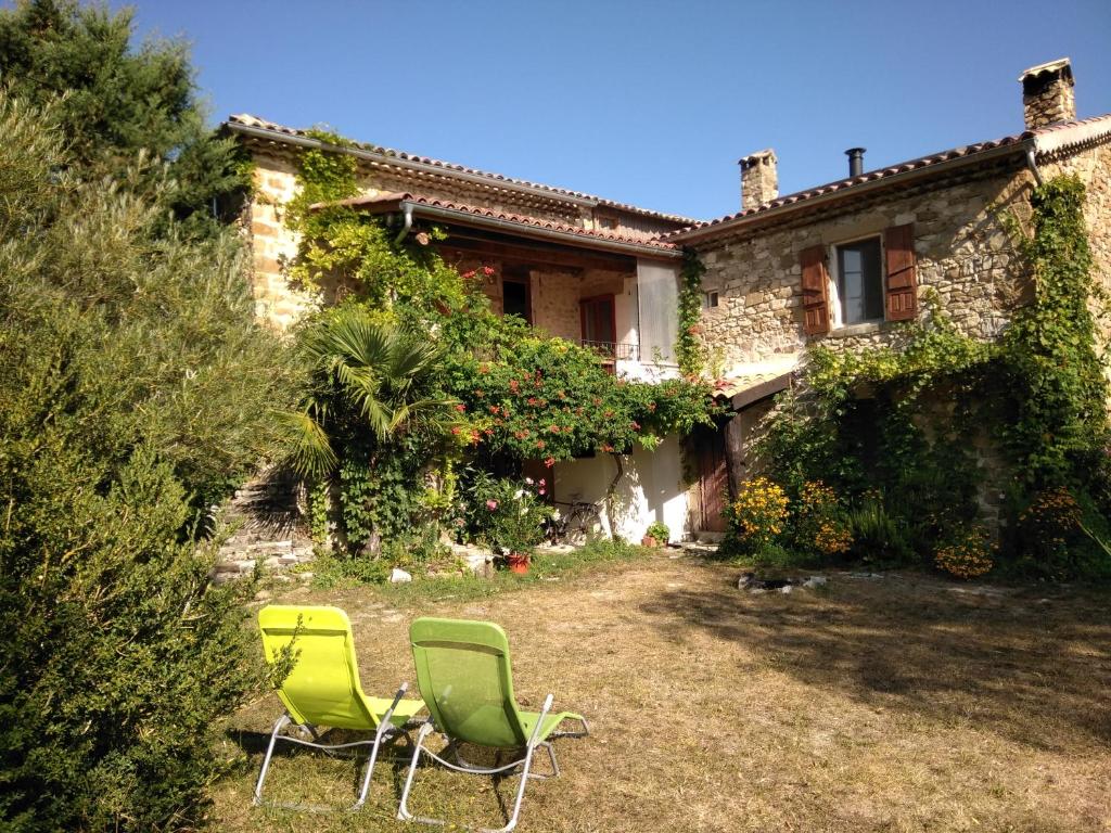 Deux chaises vertes devant une maison dans l'établissement Gites Chameyer, à Rosans