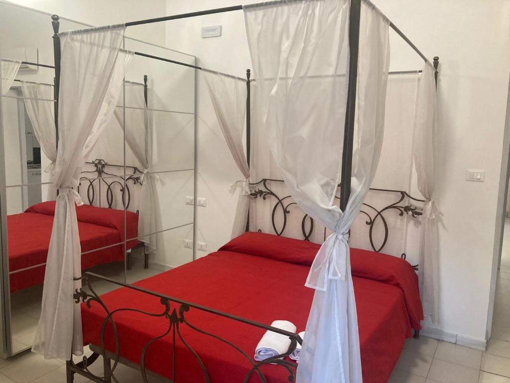 1 dormitorio con 2 camas con sábanas rojas y dosel en Casa Vacanze Mare en Pescara