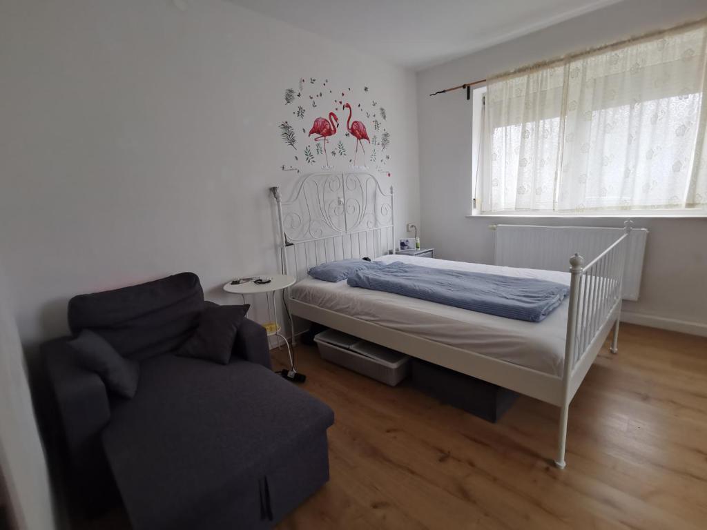 una camera con un letto e una sedia e una finestra di Tolles Möbliertes Zimmer in WG Haus in Ulm nähe Uni und Uni-Klinik a Ulma