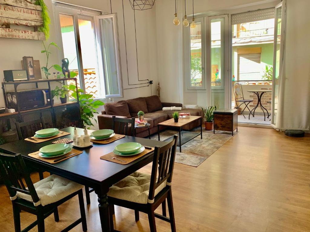salon ze stołem, krzesłami i kanapą w obiekcie Urban Greener - MORADA w Cagliari