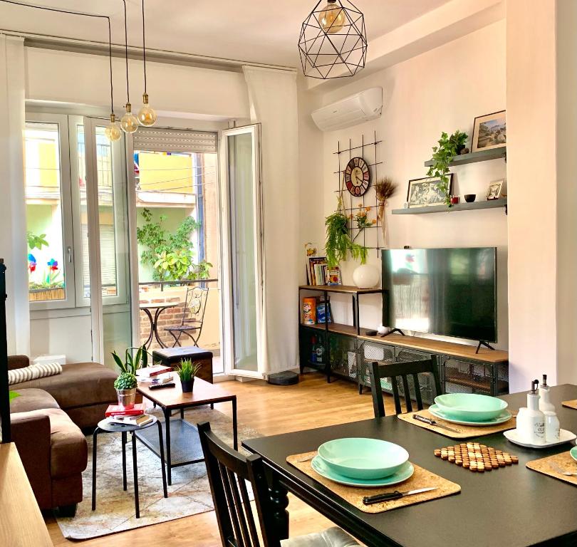 salon ze stołem i telewizorem w obiekcie Urban Greener - MORADA w Cagliari