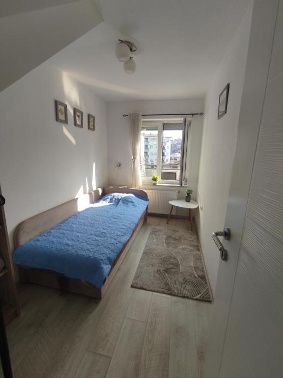a bedroom with a blue bed and a window at Apartman Mango Banja Luka center hospital Free parking in Banja Luka