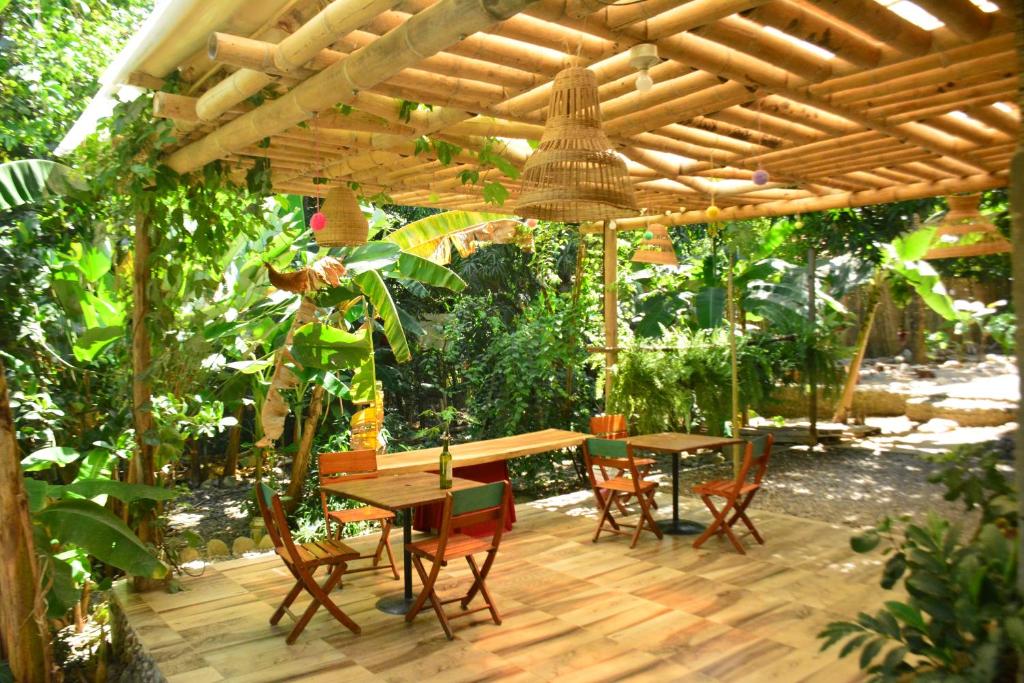 eine Holzterrasse mit einem Tisch und Stühlen unter einer hölzernen Pergola in der Unterkunft Jui Chi MaMa in Palomino