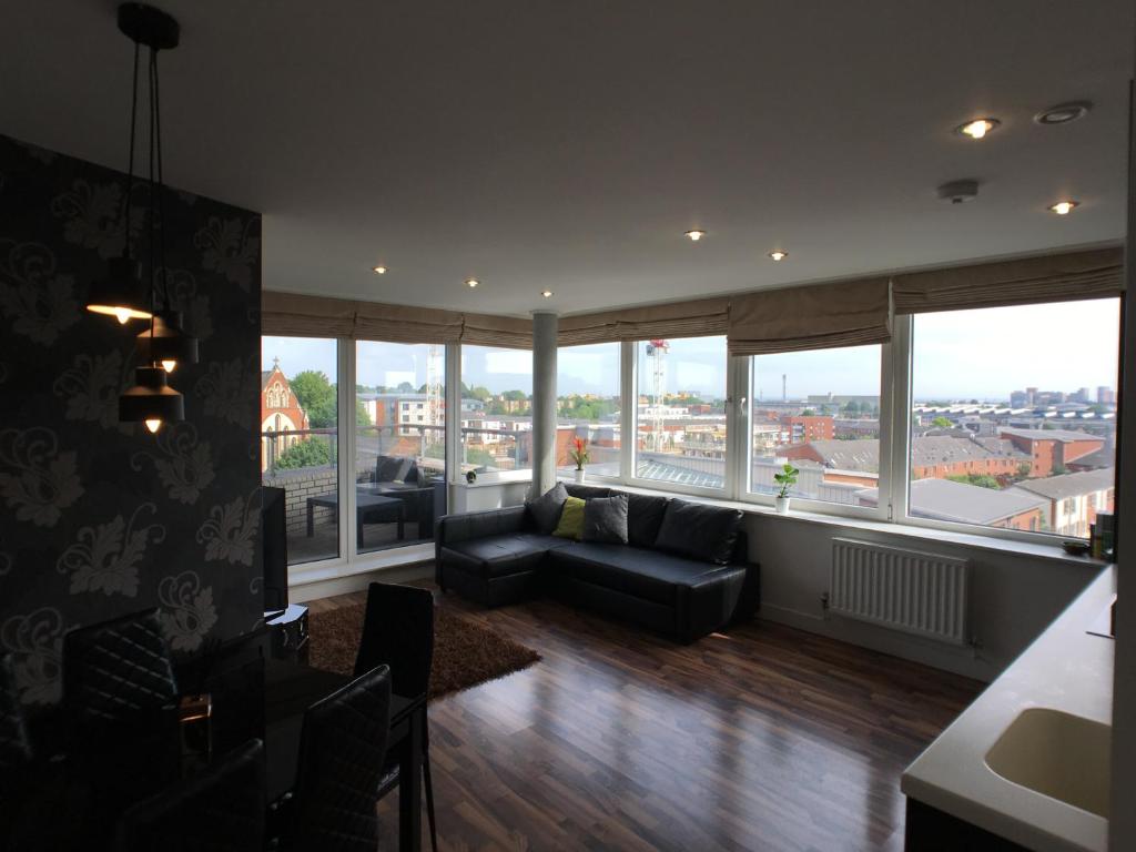 Hotel Luxury 2 Bed Penthouse Apartment near station, a living room with a couch and large windows at Luxury 2 Bed Penthouse Apartment near station in London