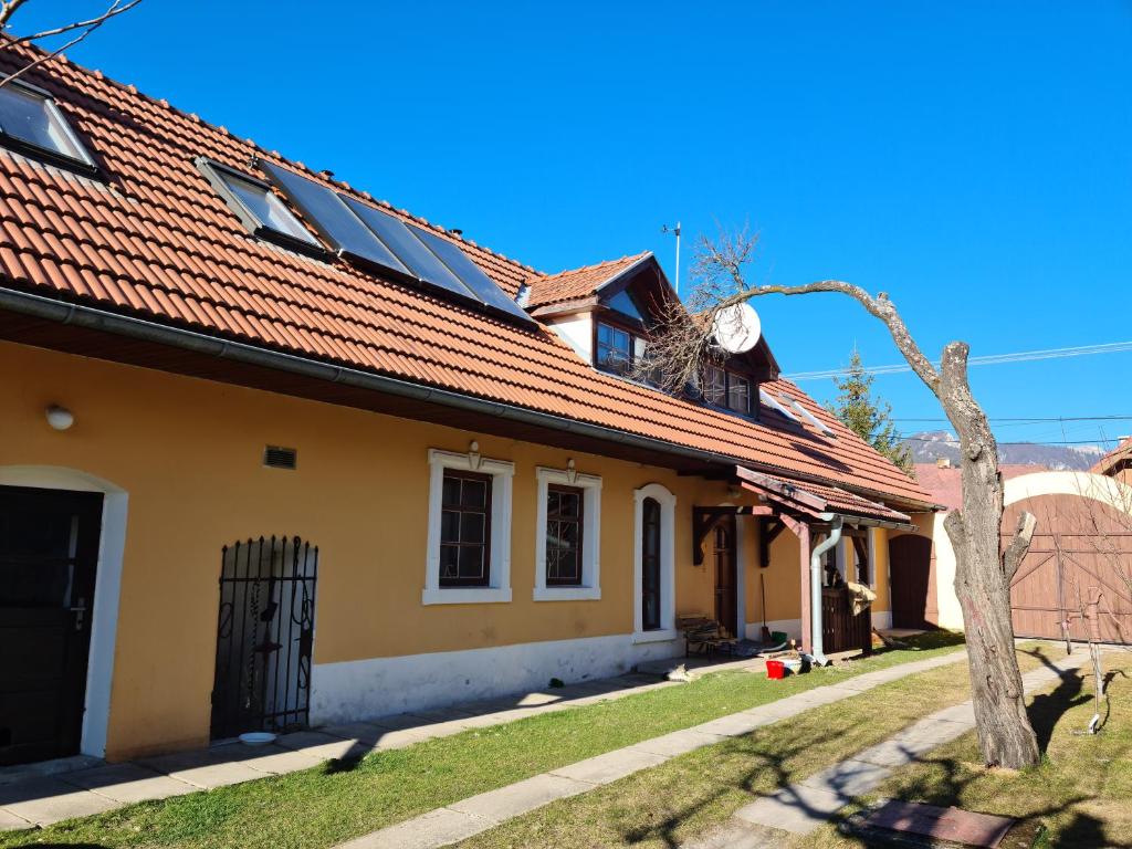 una casa amarilla con techo rojo en Penzión Larix Blatnica en Blatnica