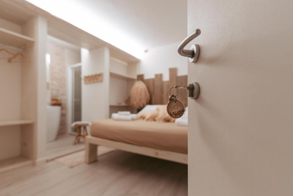 a bedroom with a bed and a bathroom at Laguna Suite B&B in Chioggia