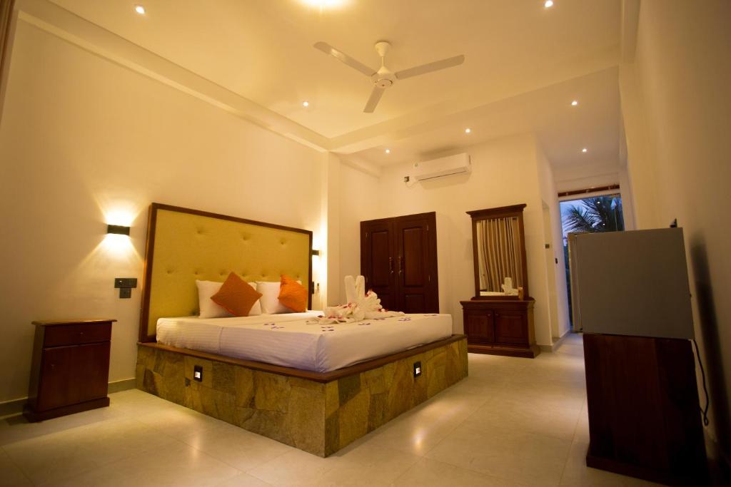 um quarto com uma cama grande num quarto em Lena Resort em Beruwala