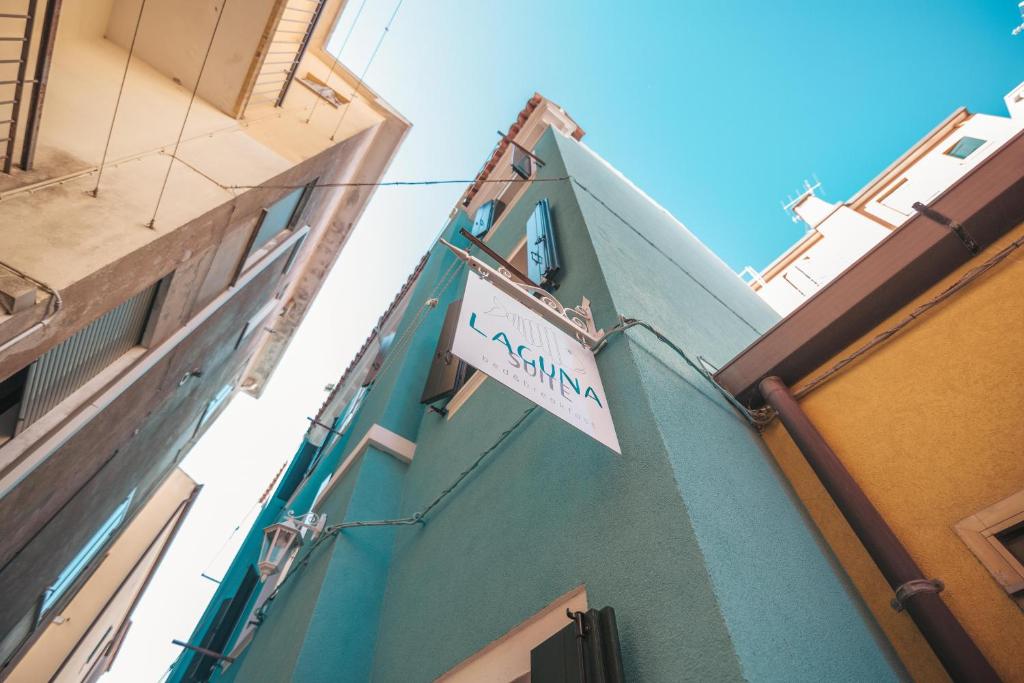 a sign on the side of a green building at Laguna Suite B&B in Chioggia