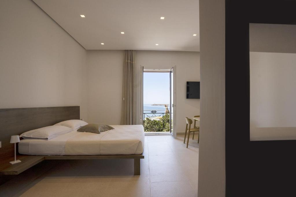 a bedroom with a bed and a view of the ocean at Kalibia rooms and suites in Mazara del Vallo
