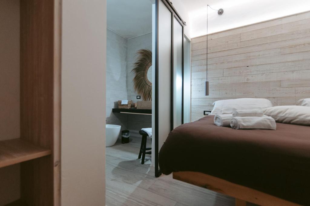 a bedroom with a bed and a bathroom with a mirror at Laguna Suite B&B in Chioggia