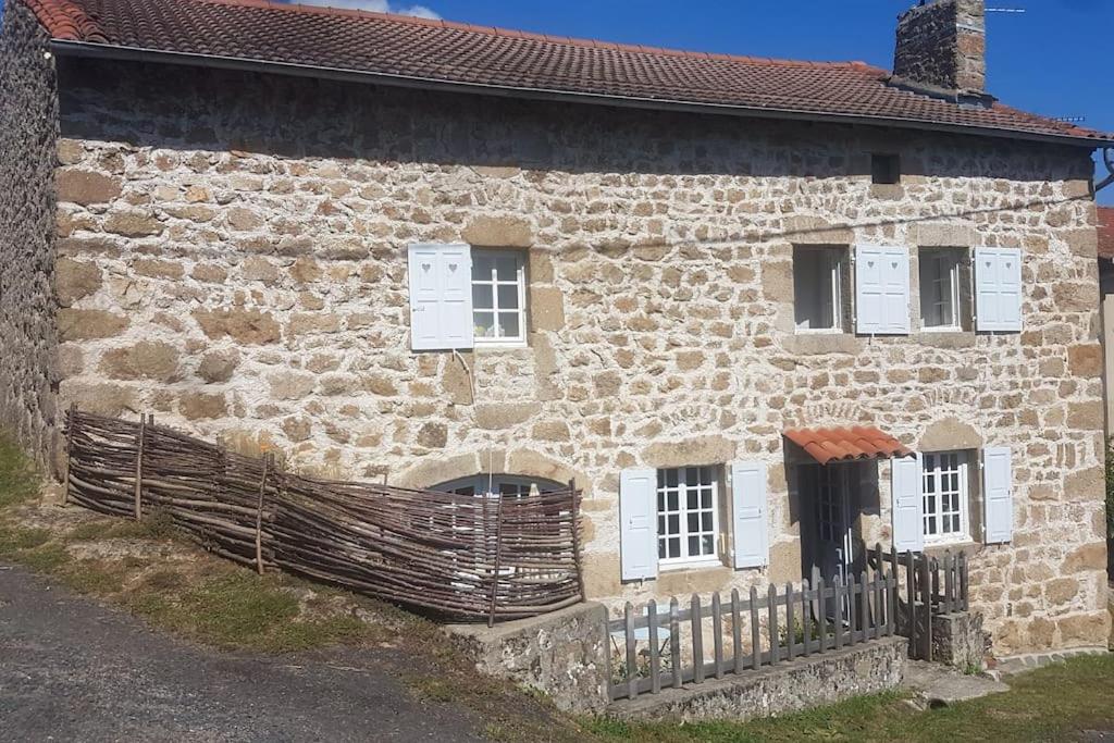 une ancienne maison en pierre avec une clôture devant elle dans l'établissement Authentique Maison de campagne De la rivière, à Saint-André-de-Chalencon
