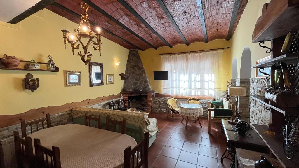 sala de estar con mesa y chimenea en LA PARRA - Casa Rural en el Valle del Jerte en Navaconcejo