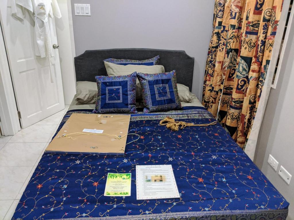 uma cama com um edredão azul e almofadas azuis em Anne's Villa em Christ Church