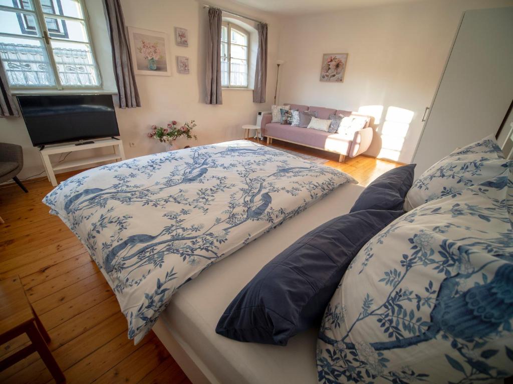a bedroom with two beds with blue and white covers at Penzion Dům u barvíře in Český Krumlov