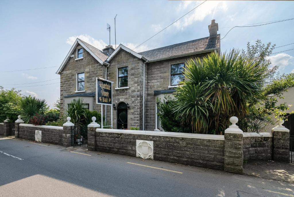 una casa con una valla de ladrillo delante de ella en Riverdale House B&B, en Athlone