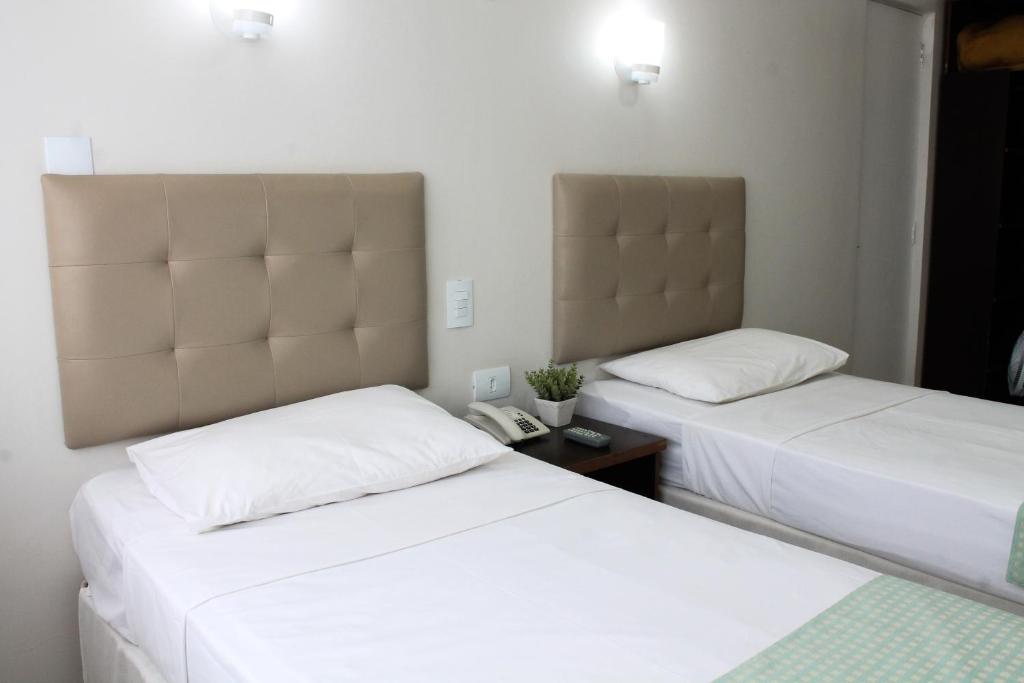 2 letti in camera d'albergo con telefono di Hotel Doral Apucarana ad Apucarana