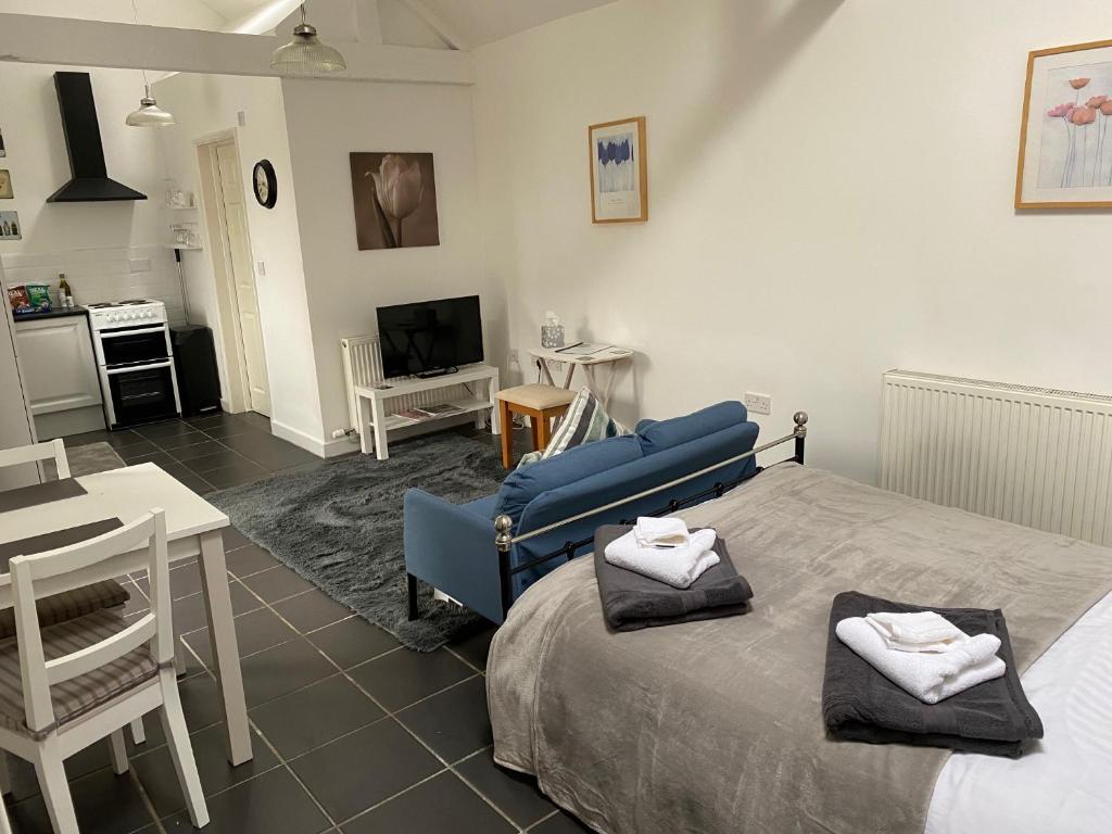 a bedroom with a blue bed and a living room at Jollys of Goodrich in Goodrich