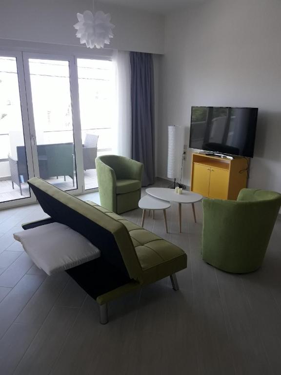 salon z kanapą, krzesłami i telewizorem w obiekcie *KASTELLINO* FULLY RENOVATED 4Beds/2Bathrooms w mieście Kisamos