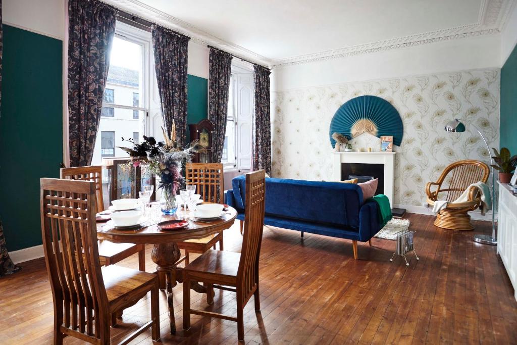 a living room with a table and a blue couch at Stylish Private Flat Near St. Andrews Golf Course in Cupar
