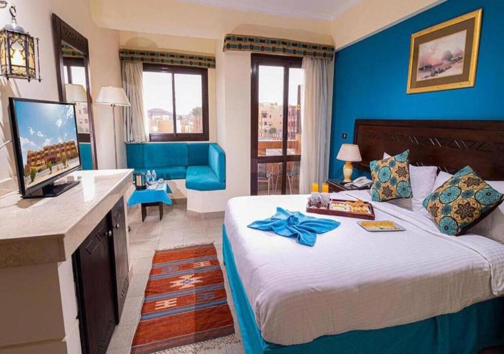 a bedroom with a large bed with a blue wall at Marina view port ghalib in Port Ghalib