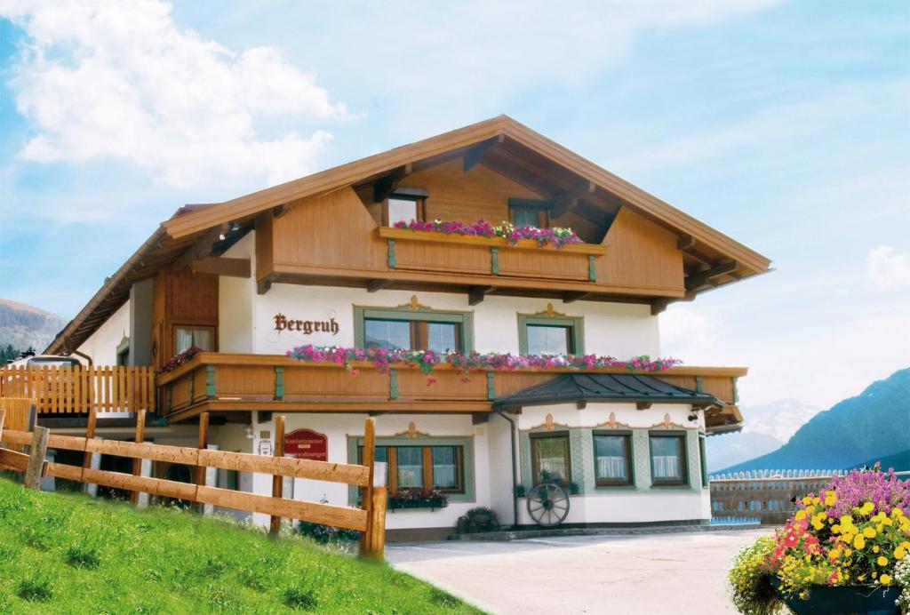 een huis in de bergen met bloemen bij Gästehaus Bergruh in Tux