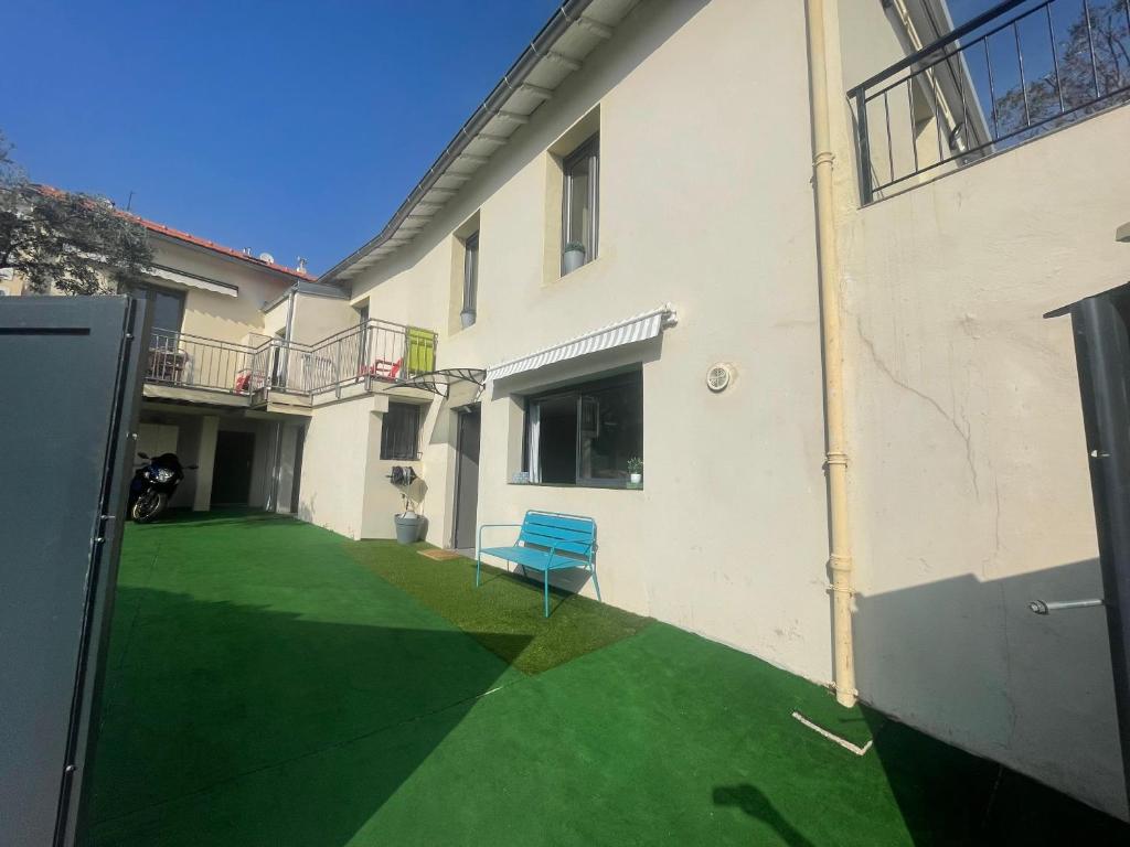 une cour avec une chaise bleue dans un bâtiment dans l'établissement Charmant deux pièces dans maison, à Roquebrune-Cap-Martin