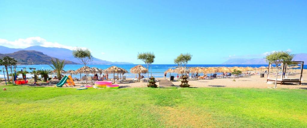 plaża z parasolami i ludzie na plaży w obiekcie *KASTELLINO* FULLY RENOVATED 4Beds/2Bathrooms w mieście Kisamos
