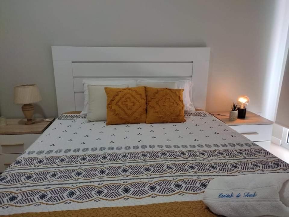 a bedroom with a large bed with two pillows at Cantinho do Sonho in Maia