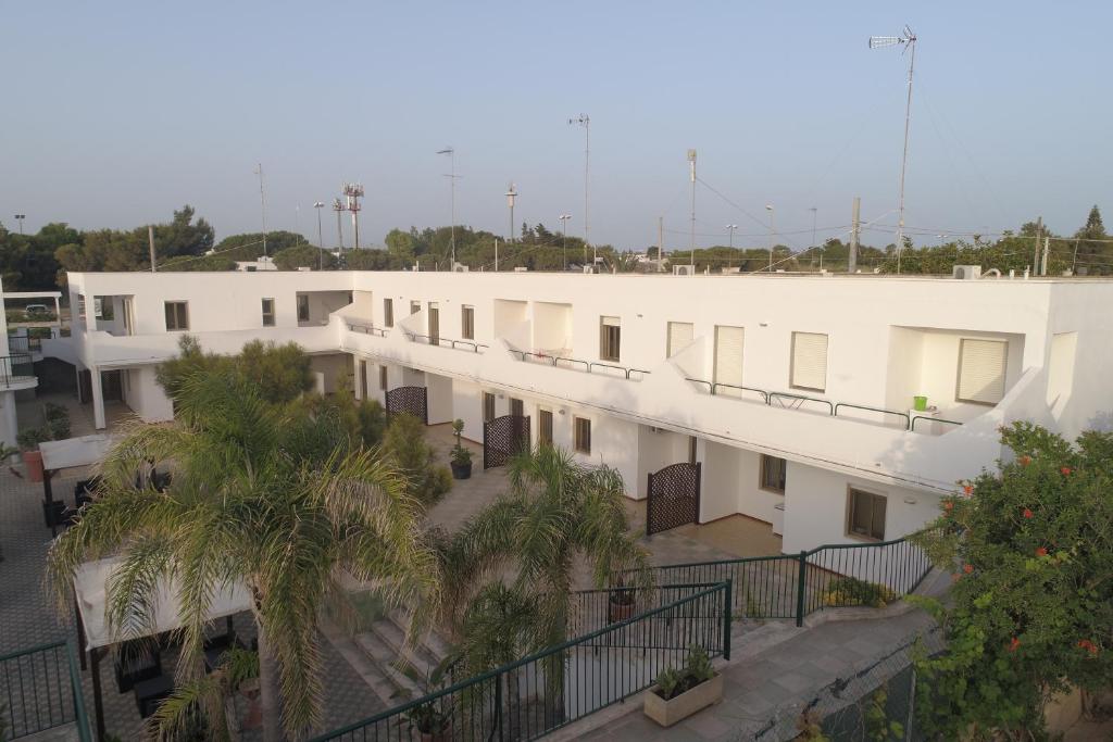 arial view of a white building with palm trees at Appartamenti Mancaversa in Marina di Mancaversa