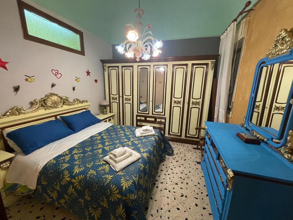 um quarto com uma cama azul e um espelho em Big Mom House em Palermo