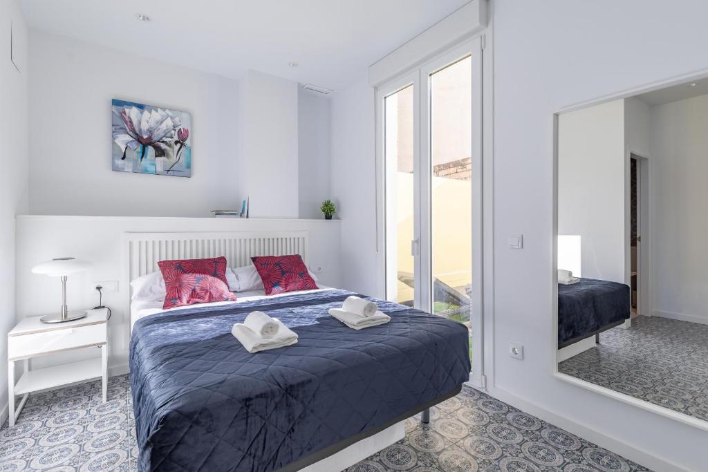 sypialnia z łóżkiem z czerwonymi poduszkami i lustrem w obiekcie Gorgeous Apt with a Large Private Terrace w Walencji
