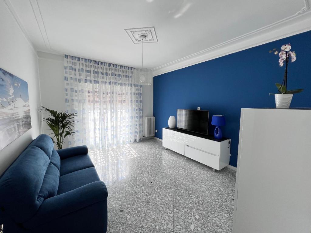 een blauwe woonkamer met een bank en een tv bij Il mare in città. Appartamento vista mare in Monopoli