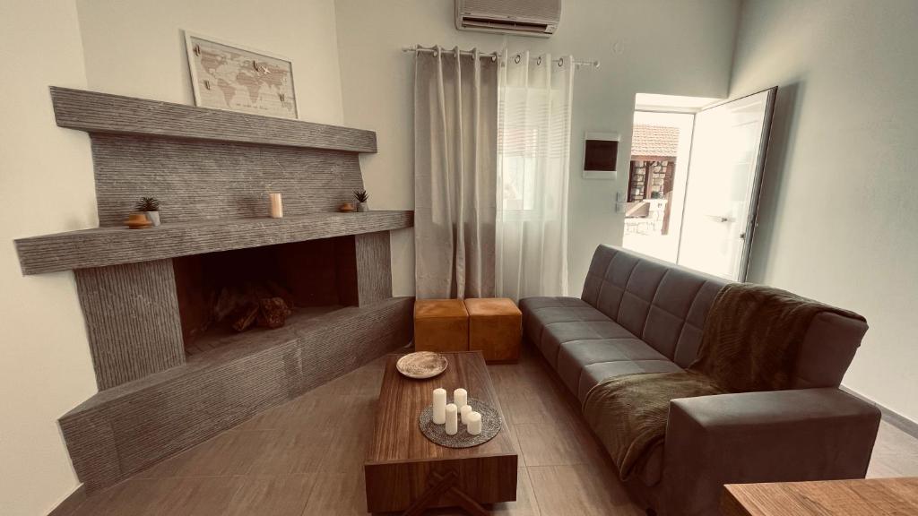 a living room with a couch and a fireplace at Elli’s House in Kalavárda