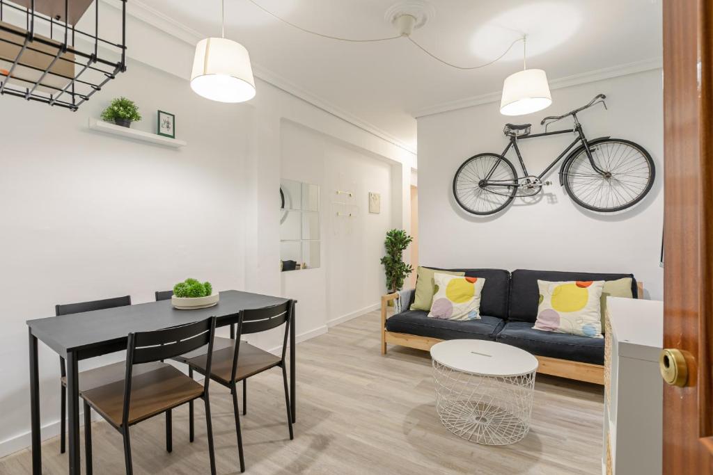 salon ze stołem i rowerem wiszącym na ścianie w obiekcie Avanti La Judería, vive Sevilla con los cinco sentidos w Sewilli