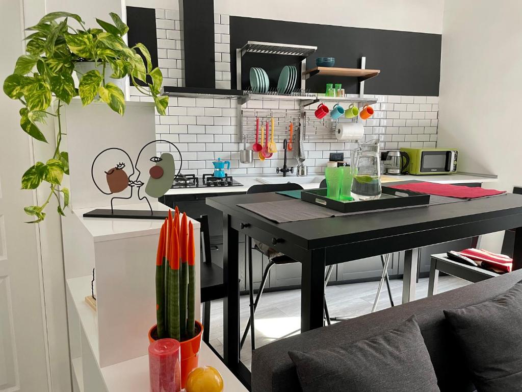 uma cozinha com uma mesa preta num quarto em Napoli Comfort Home em Nápoles