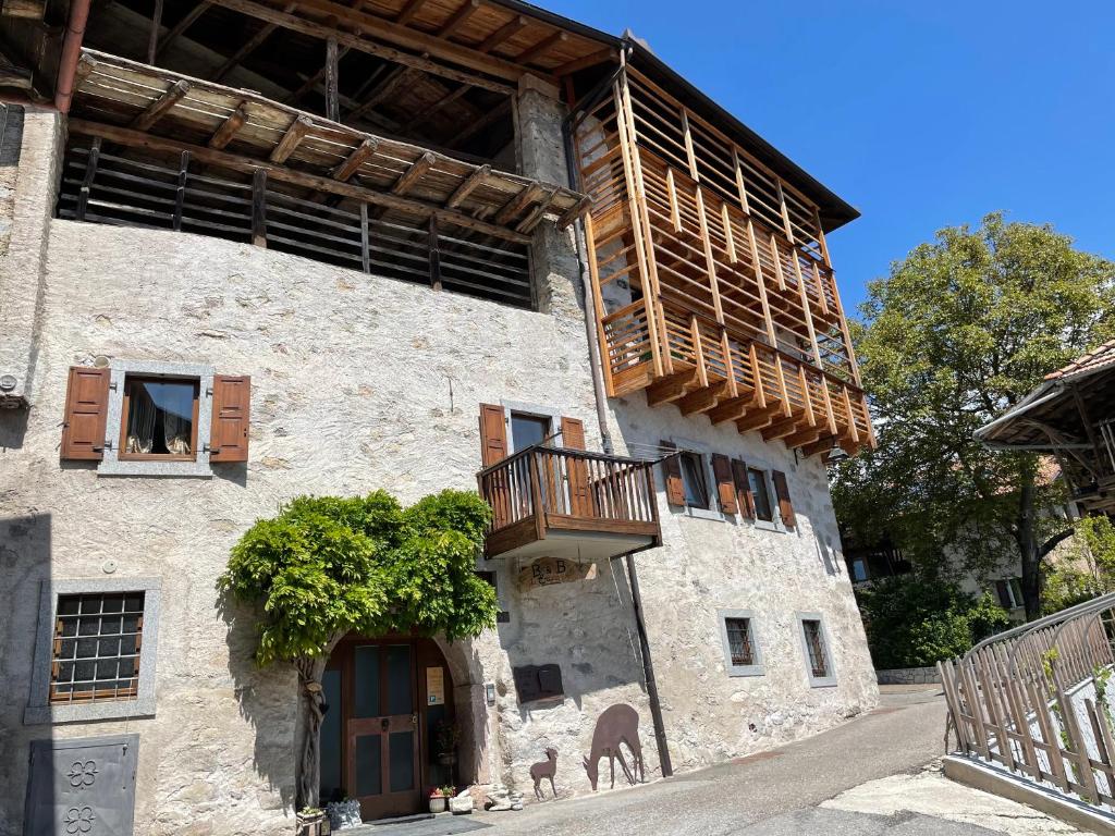 een groot stenen gebouw met een balkon bij B&B da Erica in Comano Terme