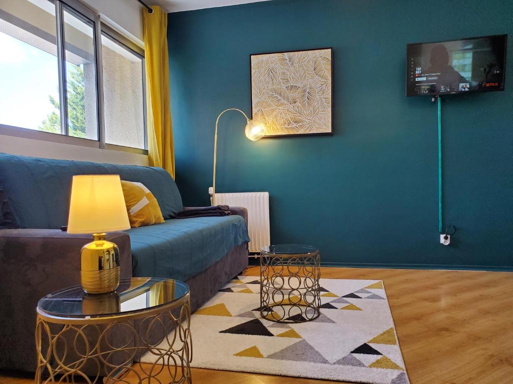 sala de estar con sofá azul y mesa en CHARMANT STUDIO☆NETFLIX☆CANAL+☆CANAL SAT☆PARKING☆, en Ramonville-Saint-Agne