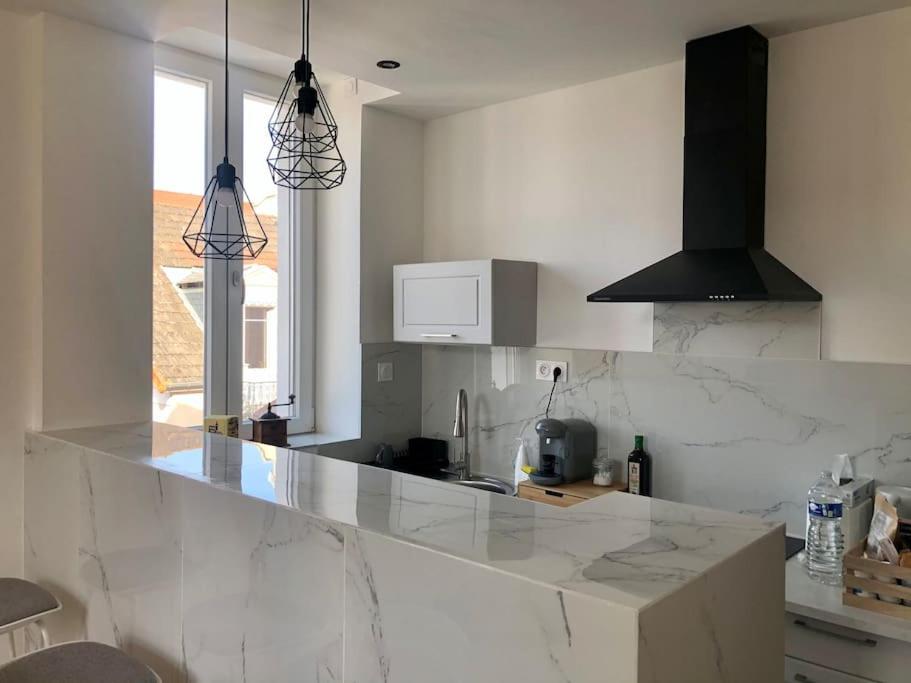 a kitchen with a white counter top in a room at Sainte Cécile 5 - T3 élégant, limineux et central in Vichy