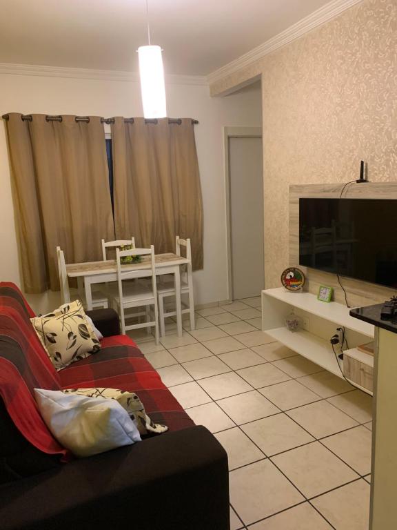 sala de estar con sofá y TV en Cantinho dos Rehm, en Fortaleza