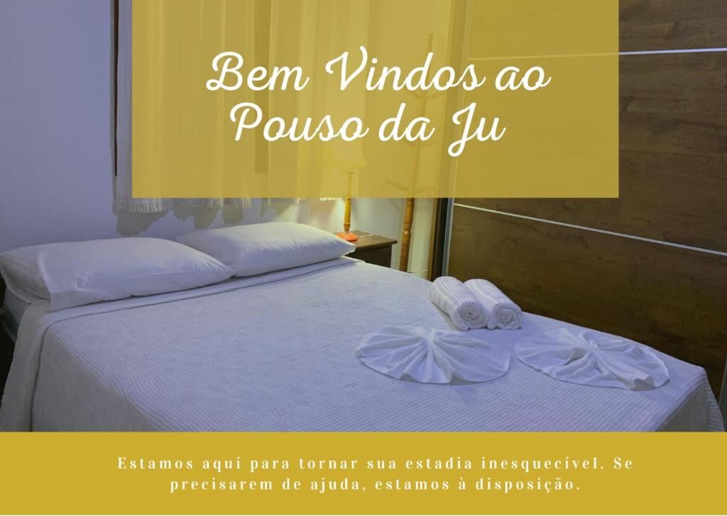 a poster of a bed with two towels on it at Pouso da Ju in Tiradentes